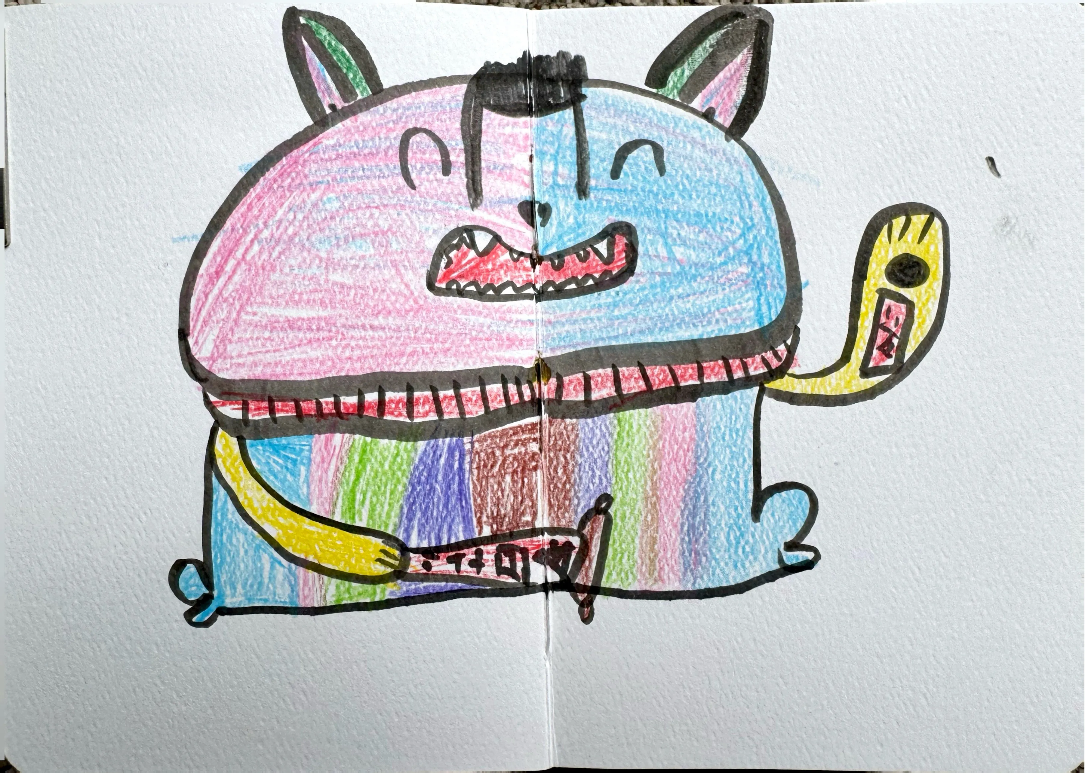A chunky, grinning cat-like monster character coloured with rainbow stripes and pastel crayon fills, outlined in black marker across a double sketchbook spread