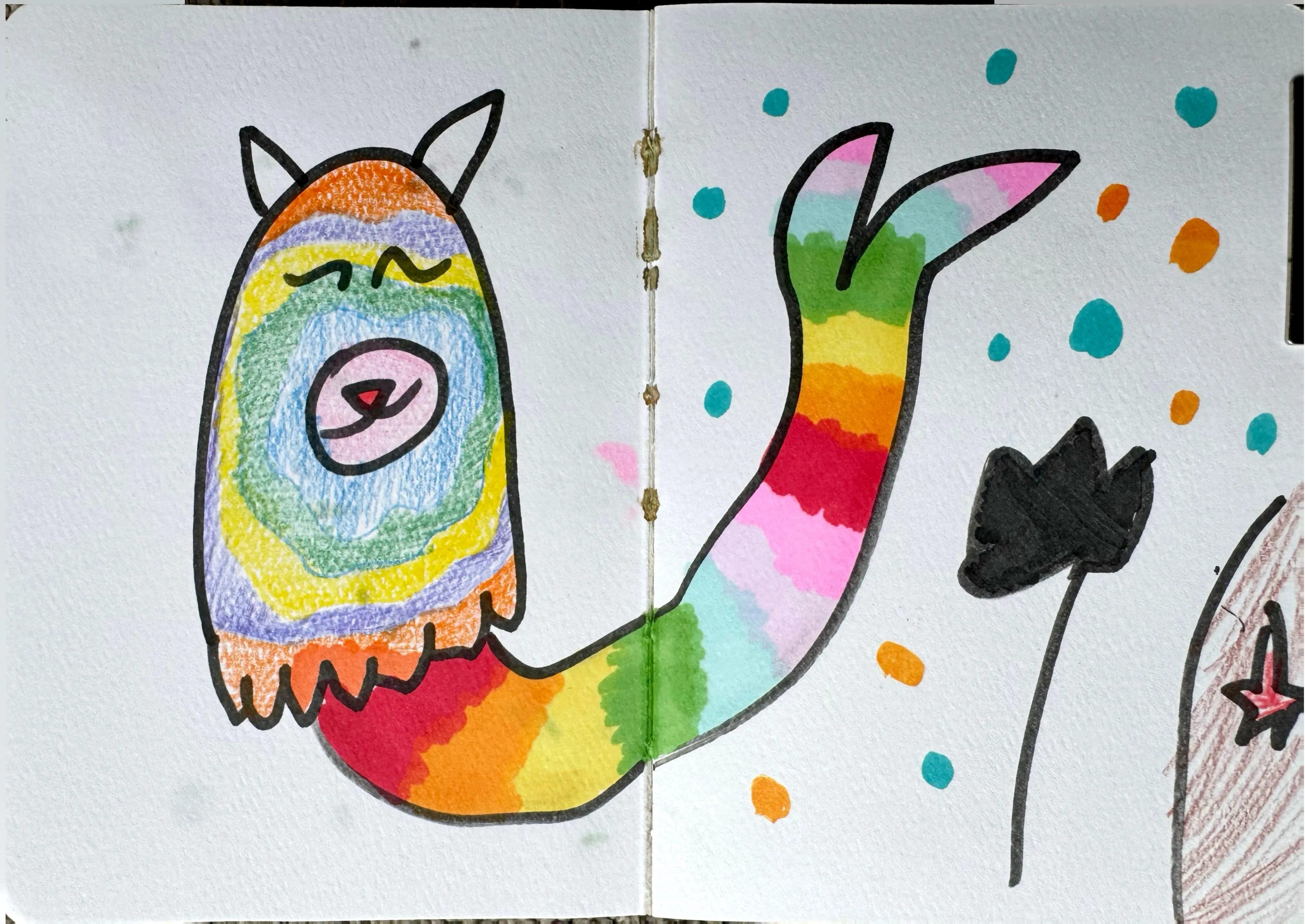A rainbow-coloured cat-mermaid hybrid creature with closed eyes and a curling tail, accompanied by colourful spots, a dark tulip, and a small star, spread across two sketchbook pages